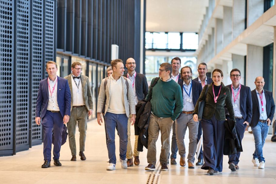 Eine Gruppe von Menschen die gemeinsam eine Messe-Gebäude durchschreiten